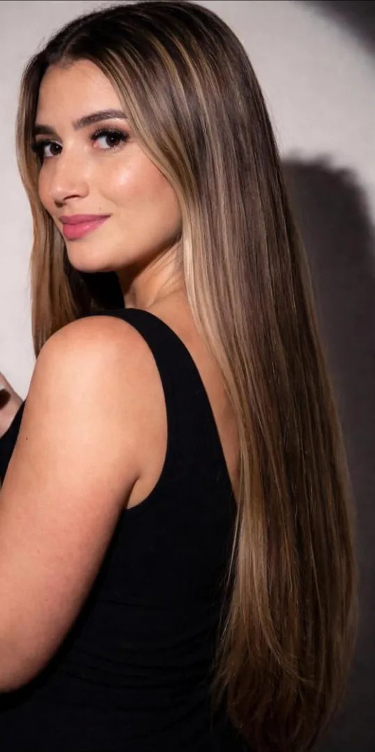 Amanda Lopes, de cabelo longo e blusa preta, sorrindo de lado